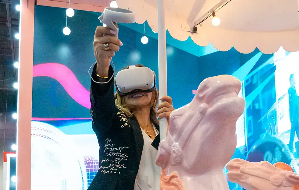 Mujer usando un visor de realidad virtual en un espacio interactivo, ilustrando una experiencia inmersiva.