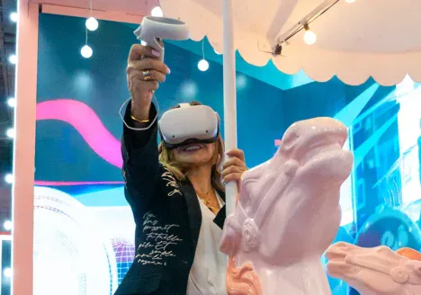Mujer usando un visor de realidad virtual en un espacio interactivo, ilustrando una experiencia inmersiva.