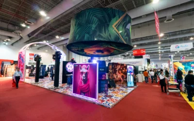 Stand BTL con diseño abierto y alto impacto visual que utiliza iluminación, gráfica y formatos envolventes para atraer al público y facilitar la circulación en un entorno de exposición profesional.