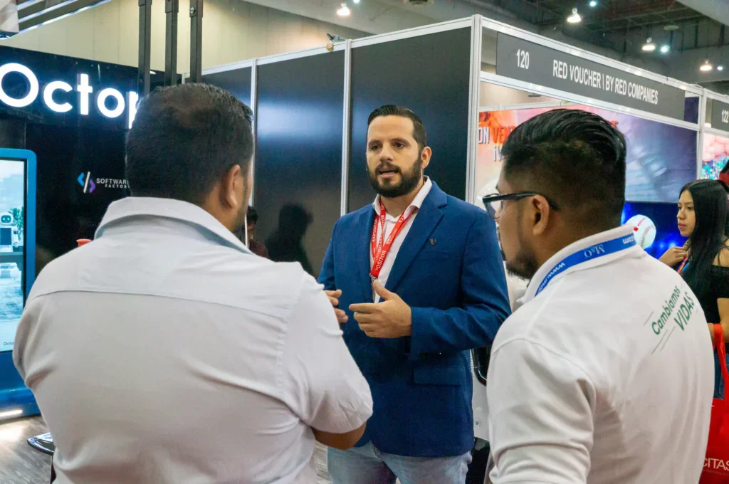 Ejecutivos y tomadores de decisión participan en conversaciones comerciales dentro de ExpoPublicitas, ejemplificando el networking B2B, el acceso a perfiles C-Level y la generación de oportunidades de negocio en el piso de exposición.