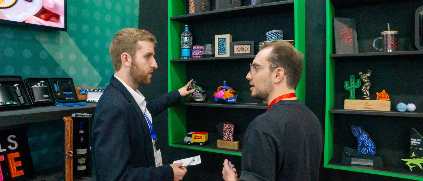 Ejecutivos conversando en un stand de digital signage durante un evento B2B, representando reuniones cara a cara, toma de decisiones y generación de oportunidades comerciales en ExpoPublicitas.
